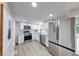 Updated kitchen boasts stainless steel appliances, modern white cabinetry, granite countertops, and new flooring at 444 Buffalo Dr, Indianapolis, IN 46217