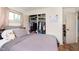 Bedroom featuring light grey bedding, wood floors, closet, and an abundance of natural light from the window at 4716 E 33Rd St, Indianapolis, IN 46218