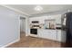 Cozy kitchen featuring white cabinets, a tile backsplash, and wood-look floors at 4716 E 33Rd St, Indianapolis, IN 46218