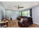 Cozy living room with wood floors, a ceiling fan, a plush leather sofa, and natural light from a window at 4716 E 33Rd St, Indianapolis, IN 46218
