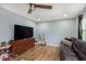 Comfortable living room featuring wood flooring, a ceiling fan, and a leather sofa at 4716 E 33Rd St, Indianapolis, IN 46218