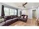 Spacious living room with wood floors, large windows with curtains, and a comfortable leather sectional sofa at 4716 E 33Rd St, Indianapolis, IN 46218