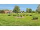 Picturesque view of a well-maintained backyard featuring a fire pit surrounded by lush greenery at 4732 Ferguson Rd, Indianapolis, IN 46239