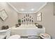 Bathroom featuring a soaking tub with a tile surround and decorative lighting at 4732 Ferguson Rd, Indianapolis, IN 46239