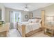 Bright bedroom with a large bed, ceiling fan, and a view of the yard at 4732 Ferguson Rd, Indianapolis, IN 46239