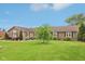 Ranch style home with professional landscaping, mature trees, plush lawn, and updated vinyl siding and roofing at 4732 Ferguson Rd, Indianapolis, IN 46239