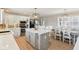 Open kitchen featuring an island with seating and stainless appliances and adjacent dining area at 4732 Ferguson Rd, Indianapolis, IN 46239
