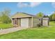 Outbuilding features a single-car garage door, a shed, and neutral color scheme at 4732 Ferguson Rd, Indianapolis, IN 46239
