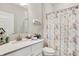 Well-lit bathroom featuring a floral shower curtain, a white vanity with a light countertop, and neutral wall paint at 4965 Eldon Dr, Noblesville, IN 46062