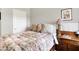 Comfortable bedroom featuring a bed with a floral quilt, side table with lamp, and classic artwork at 4965 Eldon Dr, Noblesville, IN 46062
