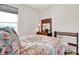 Bright bedroom features a bed with a floral quilt, side table with lamps, and natural light at 4965 Eldon Dr, Noblesville, IN 46062