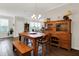 Dining room features hardwood floors, a rustic table with bench, and a view of the backyard at 4965 Eldon Dr, Noblesville, IN 46062