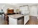 Kitchen island with stainless steel dishwasher and grey countertop between kitchen and dining area at 4965 Eldon Dr, Noblesville, IN 46062