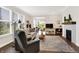 Light filled living room featuring hardwood floors, a cozy fireplace, and comfortable seating at 4965 Eldon Dr, Noblesville, IN 46062