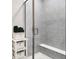 Tiled stand up shower with glass door and built in bench next to shelving at 4965 Eldon Dr, Noblesville, IN 46062