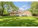 Spacious backyard with well maintained lawn, mature trees, and a back deck at 5015 E 70Th E St, Indianapolis, IN 46220
