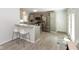Modern kitchen with stainless steel appliances, a breakfast bar, and gray cabinetry, seamlessly connecting to the dining area at 5015 E 70Th E St, Indianapolis, IN 46220