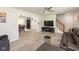 Open-concept living area with a cozy couch, modern entertainment center, staircase, and adjacent dining space at 5015 E 70Th E St, Indianapolis, IN 46220