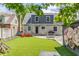 Charming backyard features artificial turf, patio area, red chairs, and a flower mural at 5224 Boulevard Pl, Indianapolis, IN 46208
