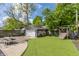 Lush backyard with artificial turf, playground, patio, and garage with floral accents at 5224 Boulevard Pl, Indianapolis, IN 46208