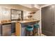 Stylish bar area featuring a wooden countertop, sleek cabinetry, bar stools, and a mirrored backsplash at 5224 Boulevard Pl, Indianapolis, IN 46208