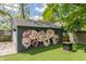 Garage with a flower mural, turf and fire pit enhances outdoor enjoyment at 5224 Boulevard Pl, Indianapolis, IN 46208