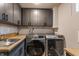 Well-lit laundry room with modern washer and dryer, cabinetry, and sink at 5224 Boulevard Pl, Indianapolis, IN 46208