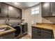 Functional laundry room with gray cabinets, wood countertop, stainless steel washer and dryer at 5224 Boulevard Pl, Indianapolis, IN 46208