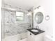 Modern bathroom with marble tile, sleek glass shower door and a vanity with a black countertop at 5721 Daphne Dr, Indianapolis, IN 46278