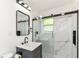 Stylish bathroom with a modern vanity, sleek black fixtures, and a frameless glass shower door at 5721 Daphne Dr, Indianapolis, IN 46278