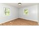 Cozy room featuring wood-look flooring, two windows offering views of the outdoors, and modern ceiling lighting at 5721 Daphne Dr, Indianapolis, IN 46278