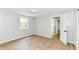 A bedroom with light gray walls, hardwood floors, and view of an open door at 5721 Daphne Dr, Indianapolis, IN 46278