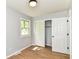 Well-lit bedroom boasts wood-look flooring, closet, and a window, creating a pleasant living space at 5721 Daphne Dr, Indianapolis, IN 46278