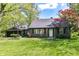 Charming home with a well-manicured lawn, dark siding, and mature trees creating a welcoming curb appeal at 5721 Daphne Dr, Indianapolis, IN 46278