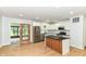 Modern kitchen featuring stainless steel appliances, white cabinetry, black countertops, island and a sliding door at 5721 Daphne Dr, Indianapolis, IN 46278
