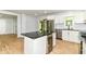 Kitchen features a center island with counter seating and a wine cooler, stainless steel appliances, and white cabinets at 5721 Daphne Dr, Indianapolis, IN 46278