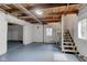 Unfinished basement with open ceiling beams and stairs at 5811 King Ave, Indianapolis, IN 46228