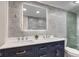 Modern bathroom featuring a double vanity with gray tiling and an illuminated mirror at 5811 King Ave, Indianapolis, IN 46228