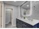 Bright bathroom featuring a double vanity with gray tiling and an illuminated mirror at 5811 King Ave, Indianapolis, IN 46228