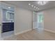 Bright bedroom with hardwood floors, with access to a sunroom and full bath with blue vanity at 5811 King Ave, Indianapolis, IN 46228