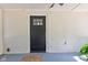 Covered front porch featuring a black front door and ceiling fan at 5811 King Ave, Indianapolis, IN 46228