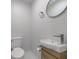 Powder room featuring a toilet and stylish sink with a wooden cabinet at 5811 King Ave, Indianapolis, IN 46228