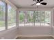 Sunroom featuring a ceiling fan and large windows offering ample natural light and wooded views at 5811 King Ave, Indianapolis, IN 46228