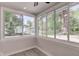 Enclosed sunroom featuring large windows offering beautiful views of the lush backyard at 5811 King Ave, Indianapolis, IN 46228