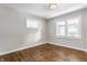 Empty bedroom featuring dark wood floors, neutral paint, and natural light from windows at 5912 Evanston Ave, Indianapolis, IN 46220