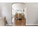 View of the dining room with seating for four and hardwood flooring, leading into the bright white kitchen at 5912 Evanston Ave, Indianapolis, IN 46220