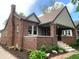 Quaint brick house with a cozy front porch, well-kept landscaping, inviting entrance, and architectural charm at 5912 Evanston Ave, Indianapolis, IN 46220