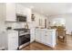 Bright kitchen features stainless steel oven, white cabinetry, and flows into the dining room at 5912 Evanston Ave, Indianapolis, IN 46220