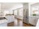 Open kitchen boasts stainless steel appliances, white cabinetry, and flows into the dining room at 5912 Evanston Ave, Indianapolis, IN 46220