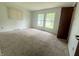 A bright bedroom with neutral walls, large windows offering outdoor views, and plush carpeting at 6335 Linden Dr, Indianapolis, IN 46227